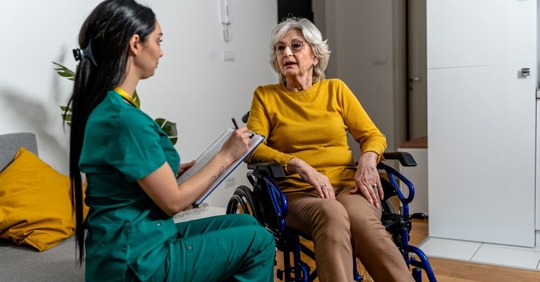 nurse talking to woman in nursing home