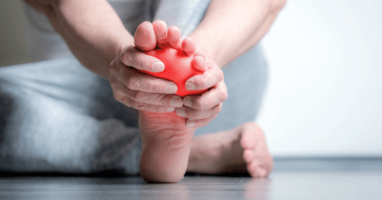 Person grabbing foot in pain