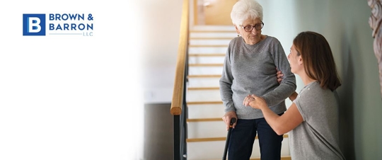 Woman helps elderly woman down stairs