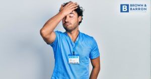 Male nurse with hand on head