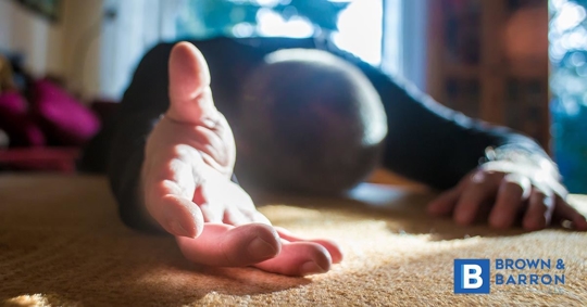 An elderly man has fallen with his hand extended