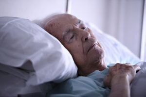 Older man laying in bed