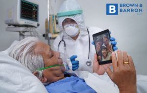 Older man in the hospital talking to family through the phone