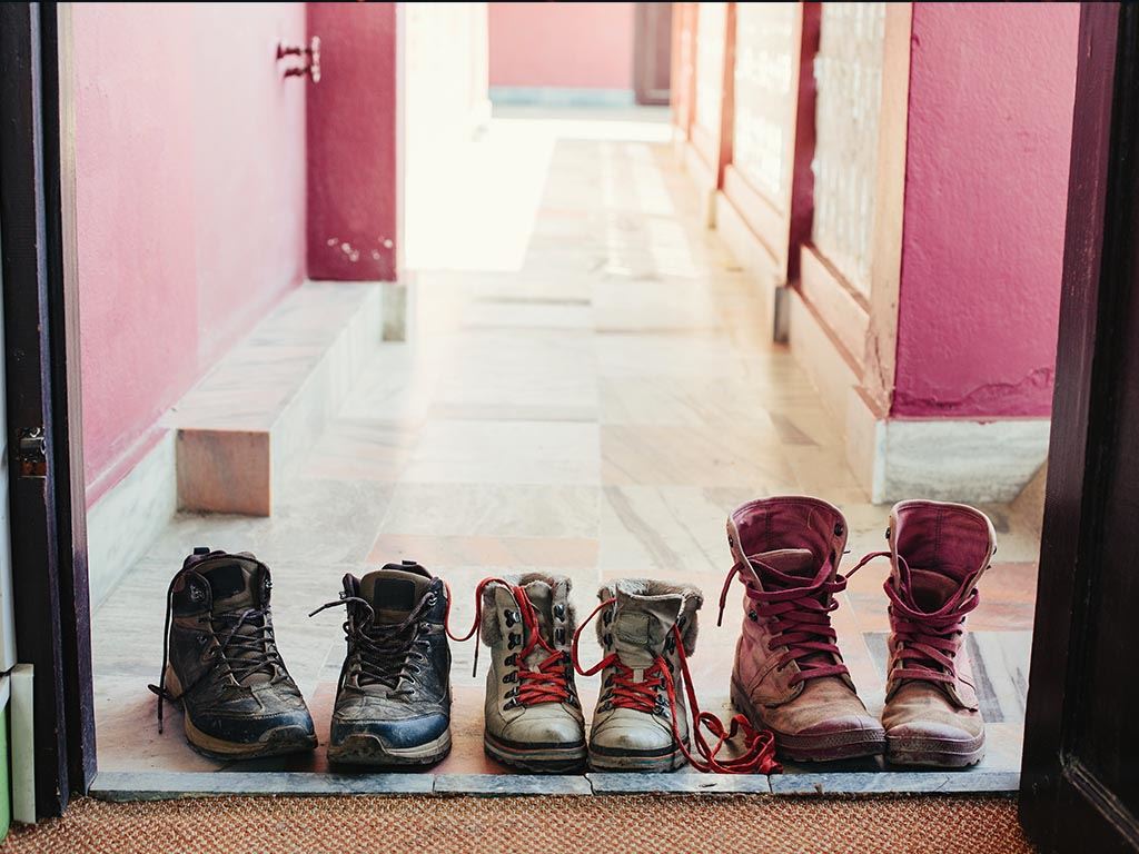 3 Pairs of Boots Sitting Outside a Door